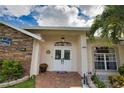 Front entry with double doors, stonework, and landscaping at 5280 E Sunnydale Cir, Sarasota, FL 34233