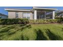 Back of house with screened patio and well-maintained yard at 1622 Monarch Dr # 1622, Venice, FL 34293
