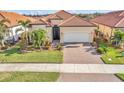 One-story home with tile roof, two-car garage, and landscaped yard at 25143 Spartina Dr, Venice, FL 34293