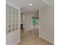 Bright entryway with tiled floors and glass block wall at 877 Tartan Dr # 102, Venice, FL 34293