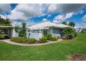 Light blue condo with carport, landscaping, and walkway at 451 Wexford Cir, Venice, FL 34293