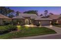 Well-lit home at dusk showcasing architectural details and landscaping at 1136 Highland Greens Dr, Venice, FL 34285