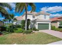 Two-story house with tile roof, green garage door, and beautiful landscaping at 23787 Waverly Cir, Venice, FL 34293