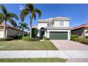 Two-story house with tile roof, green garage door, and lush landscaping at 23787 Waverly Cir, Venice, FL 34293