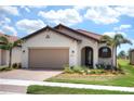Single-story home with tan garage door and red tile roof at 24273 Spartina Dr, Venice, FL 34293