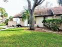 Condo with a large tree and grassy yard at 5650 Mashie Cir, North Port, FL 34287