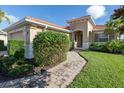 Tan house with tile roof, landscaped yard, and walkway at 126 Cipriani Way, North Venice, FL 34275