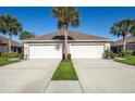 Two-villa exterior with three-car garages and landscaping at 4195 Fairway Pl, North Port, FL 34287