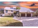 Two-story home with metal roof and stone accents at 4024 Casey Key Rd, Nokomis, FL 34275