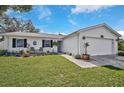 White single story home with blue door and spacious yard at 6738 Brentford Rd, Sarasota, FL 34241