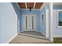 Front entrance featuring double white doors and light blue siding at 1247 Graham Rd, Venice, FL 34293