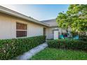 Landscaped front exterior of home with a walkway to the front door and bright blue outdoor seating at 172 Southampton Pl # 346, Venice, FL 34293
