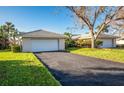 Attached one-car garage with a driveway and well-maintained lawn and mature trees on a sunny day at 172 Southampton Pl # 346, Venice, FL 34293