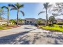 House exterior view with driveway, landscaping, and palm trees at 192 Grand Oak Cir, Venice, FL 34292