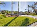 Expansive front yard with mature palm trees, lush green grass, and well-maintained landscaping add great curb appeal at 192 Grand Oak Cir, Venice, FL 34292