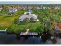 Aerial view of single-story home with private dock and lush landscaping at 4646 Fallon Cir, Port Charlotte, FL 33948