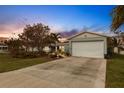 House exterior featuring a light blue color, a white garage door, and landscaping at 852 E 6Th St, Englewood, FL 34223