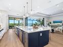 Modern kitchen island with stainless steel appliances and open views of the living room and water at 1109 Bayshore Rd, Nokomis, FL 34275