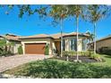 Single-story home with brown garage door and palm trees at 13848 Rinuccio St, Venice, FL 34293