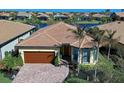 Single-story home with brown garage door and palm trees at 13848 Rinuccio St, Venice, FL 34293