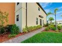 Neatly landscaped side yard with a brick pathway leading to the back at 20391 Lagente Cir, Venice, FL 34293