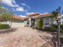 House exterior showcasing a paver driveway and palm trees at 4245 Via Del Villetti Dr, Venice, FL 34293