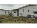 This home has a lawn, a concrete pad, a covered patio and an air conditioning unit at 6234 Parakeet Rd, Englewood, FL 34224