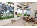 Sunroom with lake view, wicker furniture, and tiled floor at 649 Crossfield Cir # 10, Venice, FL 34293