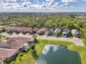 Wide shot of a neighborhood with houses near a pond at 9973 Holopaw St, Englewood, FL 34223