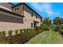 Landscaped side yard with lush greenery, leading to a private entrance at 10055 Crooked Creek Dr # 103, Venice, FL 34293