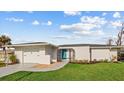 House exterior showcasing freshly painted home with teal door and landscaping at 116 Caddy Rd, Rotonda West, FL 33947