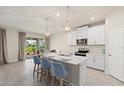 Modern kitchen with white cabinets and island at 11925 Bohemian Pl, Venice, FL 34293
