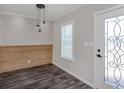 Bright entryway featuring stylish light fixtures, wood accent wall, decorative door, and luxury vinyl plank flooring at 127 Nautical Dr, North Port, FL 34287