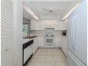 Efficient kitchen with white cabinets and appliances at 841 Waterside Dr # 206, Venice, FL 34285