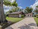 Attractive home exterior with stone and siding, and a spacious paved driveway at 1141 Sleepy Hollow Ct, Venice, FL 34285