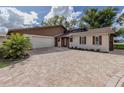 Updated home exterior with stone, siding, and a large paved driveway at 1141 Sleepy Hollow Ct, Venice, FL 34285