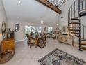 Open dining area with spiral staircase, chandelier, and tiled floors at 1141 Sleepy Hollow Ct, Venice, FL 34285