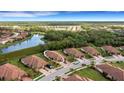 Aerial view of a home and surrounding neighborhood with a lake at 12319 Amica Loop, Venice, FL 34293