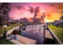 Beautiful sunset over the canal with private boat dock and seating at 1701 Boca Raton Ct, Punta Gorda, FL 33950