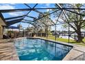 Enjoy this relaxing screened-in pool with views of the canal and tropical foliage at 1701 Boca Raton Ct, Punta Gorda, FL 33950