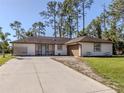 Single-story home with a brown roof, attached garage, and a spacious driveway at 3331 Traverse Ave, North Port, FL 34286