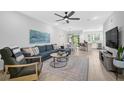 Open living room with hardwood floors, sectional sofa, and access to kitchen at 4008 Via Sienna Cir, Sarasota, FL 34243