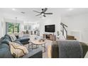 Spacious living area featuring hardwood floors, sectional sofa, and modern TV stand at 4008 Via Sienna Cir, Sarasota, FL 34243