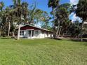 Single story home with red roof and white exterior walls, large grassy yard at 506 Kenwood Ave, Nokomis, FL 34275