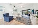 Living room with light walls, comfortable furniture, and a large TV at 6796 Gasparilla Pines Blvd # 62, Englewood, FL 34224