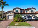 Front view of two-story townhome with two-car garage and nicely landscaped yard at 117 Porta Vecchio Bnd # 101, Nokomis, FL 34275