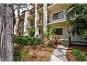 Condo building exterior showcasing landscaping and pathway at 1174 Bird Bay Way # 107, Venice, FL 34285