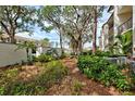 Landscaped grounds with mature trees and walkway at 1174 Bird Bay Way # 107, Venice, FL 34285
