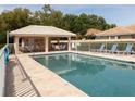 Community pool with a covered patio area and lounge chairs at 1206 Berkshire Cir, Venice, FL 34292