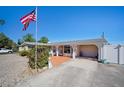 House with a brick walkway, attached garage, and American flag at 126 Venice East Blvd, Venice, FL 34293